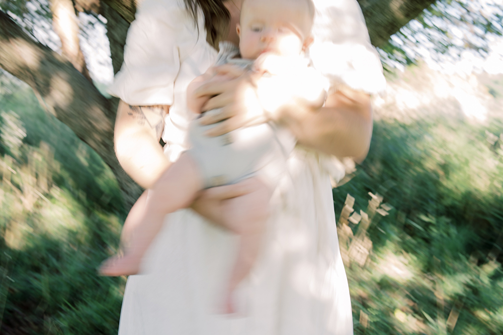 Artistic photographer of a mama and baby swaying in a sunlit field under a tree at Old Slate Farm movement | Columbus Family Photographer | Anna Laero Photographer