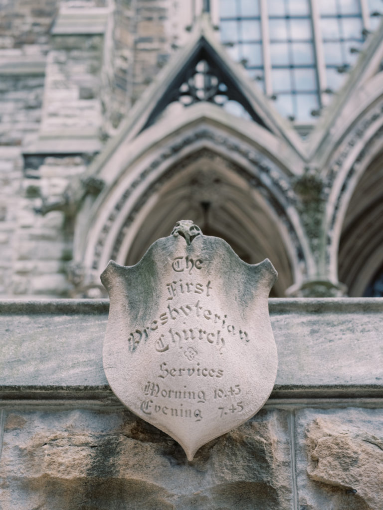 An old, carved stone sign outside the historical First Presbyterian Church Pittsburgh states when they used to have outdoor street services.