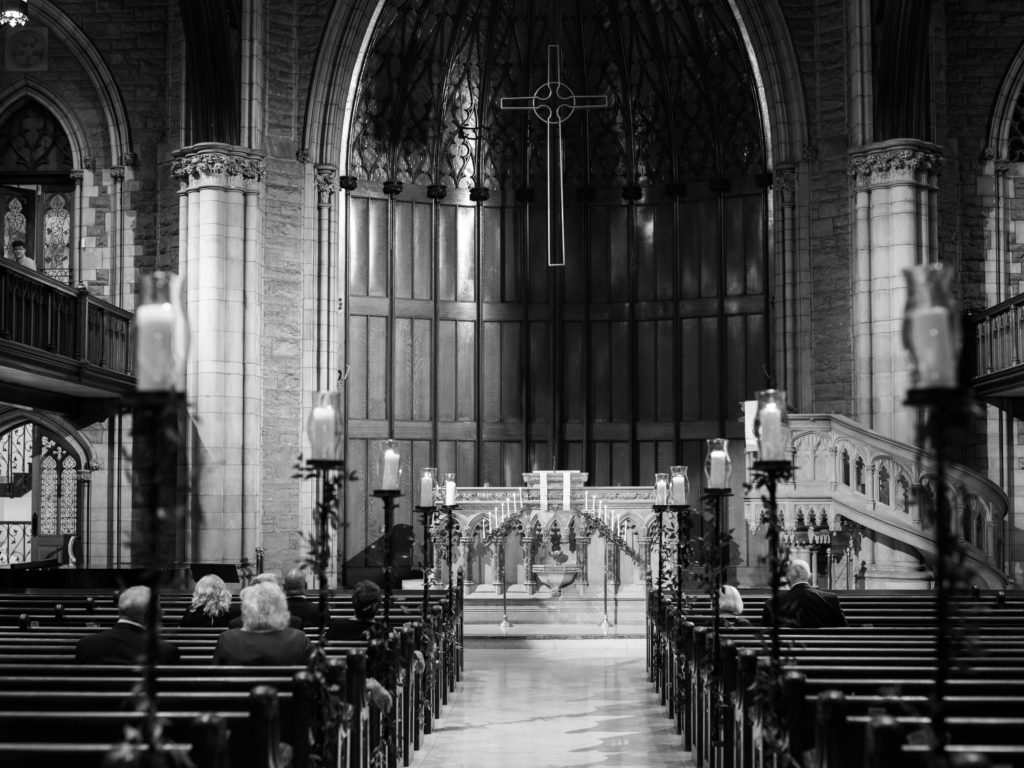 The wedding guests are arriving in this black and white photograph inside First Presbyterian Church in Pittsburgh, PA.