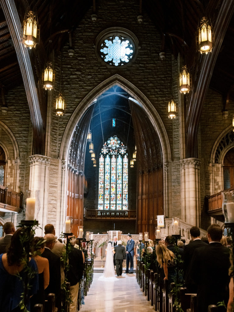The stunning beauty of this historic church illumines the bride as her father stands with her before the officiant and the groom.