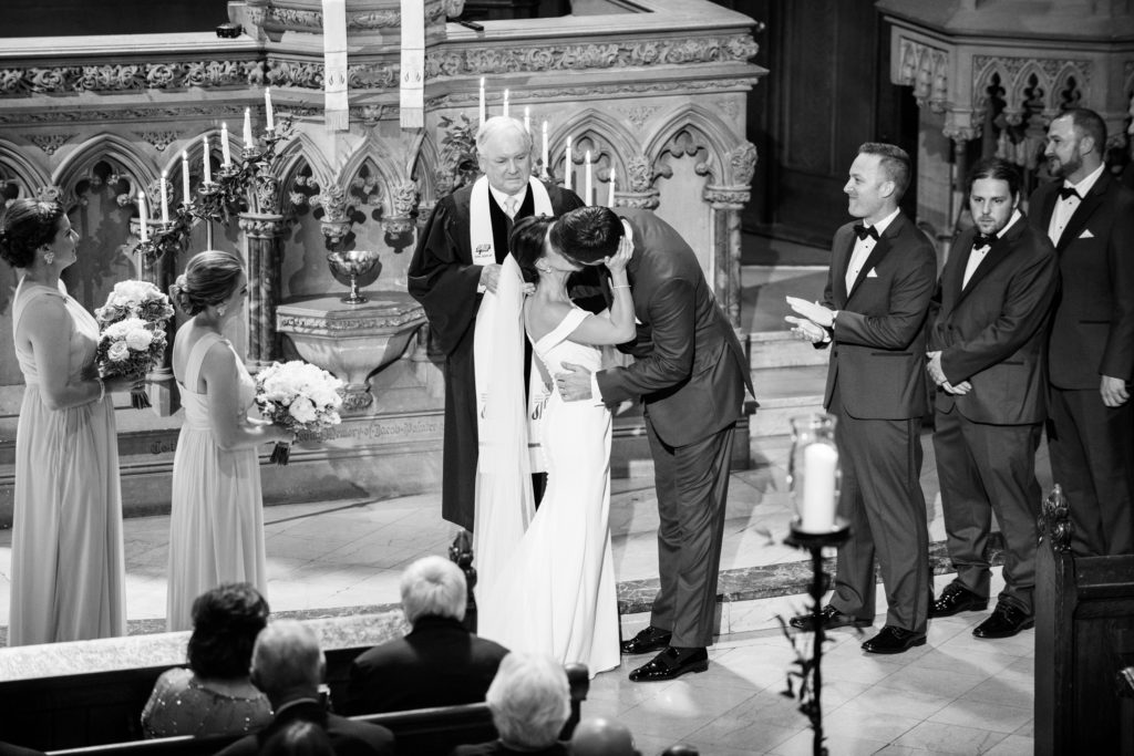 A black and white Pittsburgh wedding photography image of the bride and groom kissing as seen from the balcony.